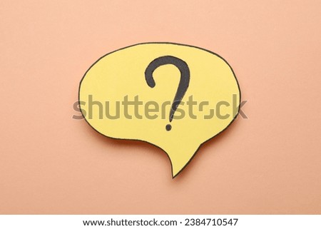 Paper speech bubble with question mark on beige background, top view
