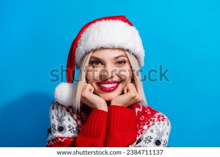 Photo of pretty peaceful lady beaming smile arms touch cheekbones christmastime isolated on blue color background