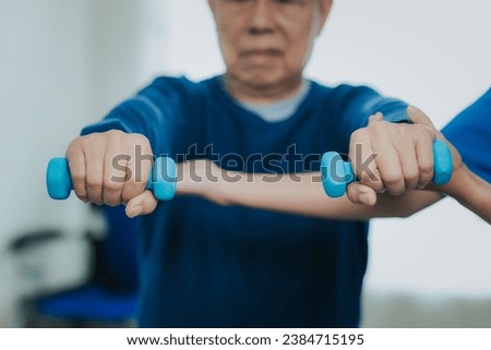Asian female doctor or nurse exercising with elderly man at hospital