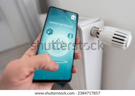 Smartphone with launched application for alarm security system, lock or unlock surveillance camera outside. Focus on mobile. Smart and safe home concept. 