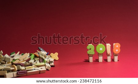 Colorful year 2018 numbers on clothes peg with red background and room for text.