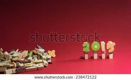 Colorful year 2015 numbers on clothes peg with red background and room for text.
