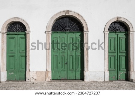 Old colonial facade with three green wooden doors. Royalty-Free Stock Photo #2384727207