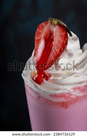 A close-up of a strawberry milkshake with cream
