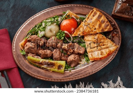 A plate of grilled lamb pieces with appetizers