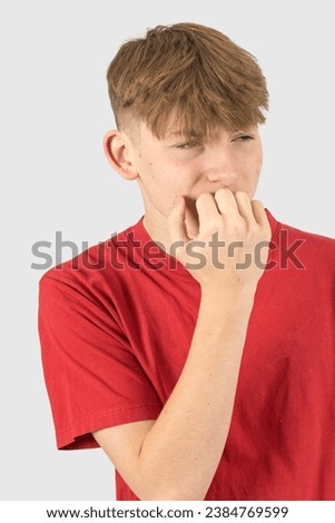 A studio portrait of a nervous fifteen year old teenage boy Royalty-Free Stock Photo #2384769599