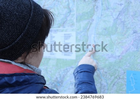 Young woman planning vacation trip with map. Aiming for the mountain top