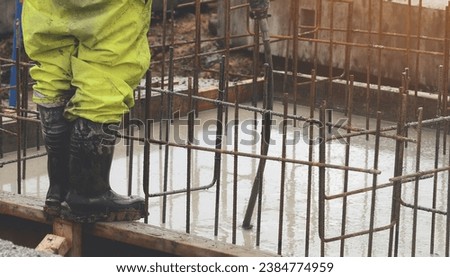 Concrete cast-in-place work. Builder level wet concrete. Concrete works on buildiiing construction site Royalty-Free Stock Photo #2384774959