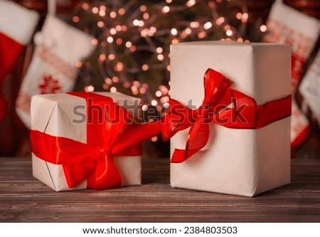 Christmas atmosphere, gifts in boxes with a red bow on the table
