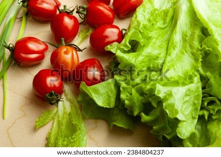 Background from green onion lettuce and tomatoes. Fresh vegetables for salad for publication, design, poster, calendar, post, screensaver, wallpaper, postcard, cover, website. High quality photography