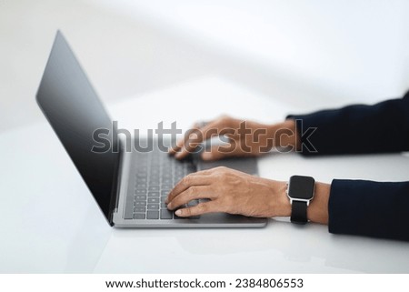 Closeup of unrecognizable middle aged businesswoman working on laptop, hands typing on computer keyboard while working in office, side view, cropped image