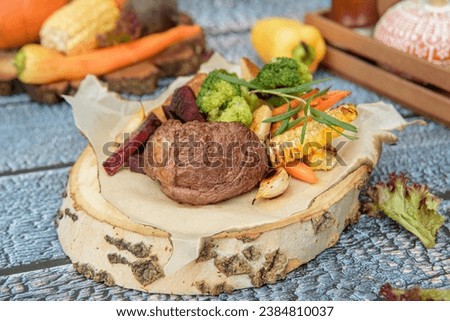 Delicious filet mignon steak with grilled vegetables.Steak filet minion, bbq steak  beef. On a wooden stump and a wooden background