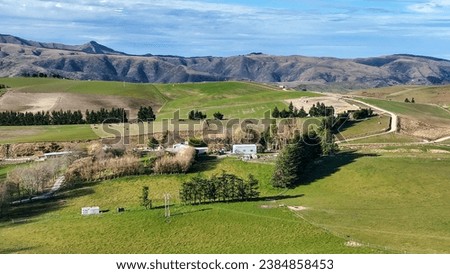 Panoramic  aerial views of mountain ranges and rolling hills and valleys covered in lush green rural agricultural  farming crop and grazing countryside