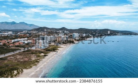 Moreno Beach on the island of margarita, where you can see its coasts, beaches, islets, fishing boats, sky, mountains, old town, boulevard, people exercising and a lagoon.
Monument angel of rock