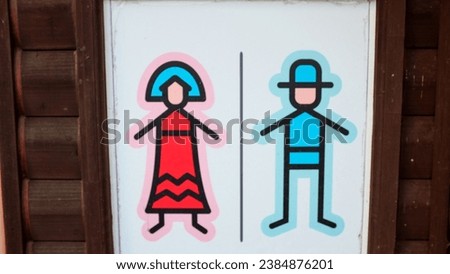 bathroom sign showing man and woman with hats