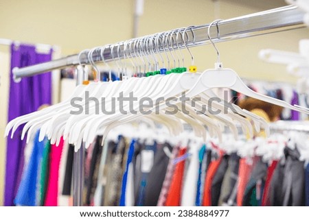 Empty plastic hangers hang on chrome cornice at entrance of a store fitting room online orders close-upCollection sale, stock, fashion outlet Collection sale, stock, fashion outlet Storage Inventory