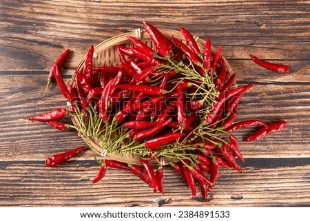 A bunch of ripe red hot chili peppers on wooden table. Royalty-Free Stock Photo #2384891533