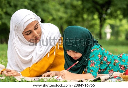 Portrait of happy religious enjoy happy love asian islam family muslim mother and little muslim girls child with hijab dress smiling and having fun moments good time, islam, ramadan in summer park