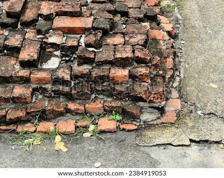a broken brick wall in the street.