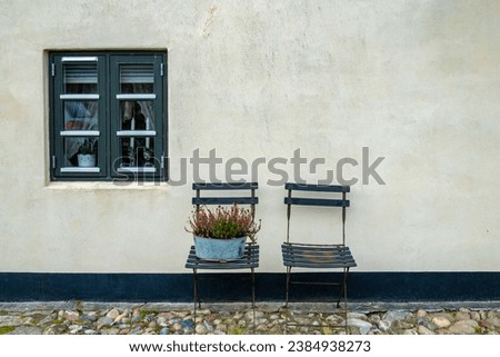 Lonstrup, Denmark Two garden chairs outside small cottage and window