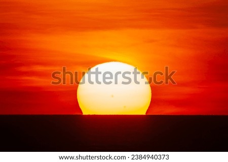 Big red dazzling sun going up from the horizon, over the sea of Xuan Thanh, Nghe An, Vietnam Royalty-Free Stock Photo #2384940373