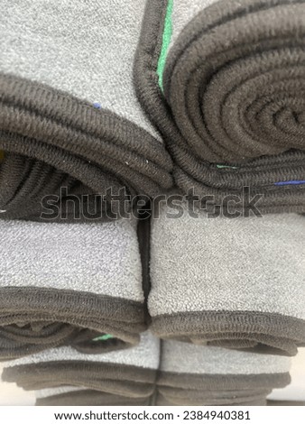 Rolls of cleaning cloths are stacked one on top of another.