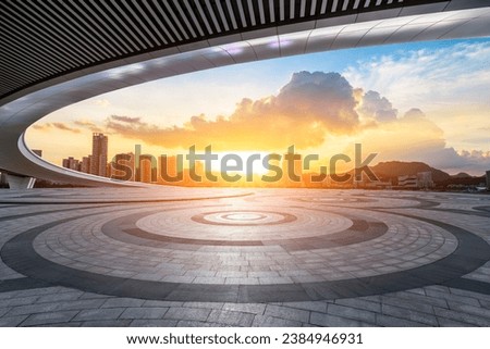 Round square floor and bridge with city skyline at sunset