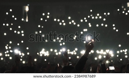 Many fun people lift hand up hold cell phone flash light. Fan crowd wave flashlights. Epic live music concert atmosphere. Big open air k pop arena. Cool night fest. Lot joy men hang out. Kpop chill. Royalty-Free Stock Photo #2384987689