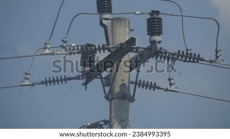 Three circuit breakers on utility poles, one of which had tripped Royalty-Free Stock Photo #2384993395