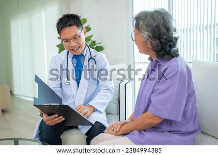 Mature male doctor taking care and talking mature female patient sitting on sofa in hospital. Healthcare concept.