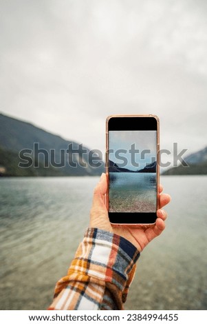 left hand man hold mobile phone with natural background