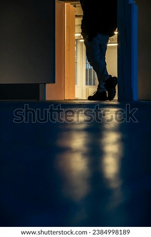 Odense, Denmark A man's feet stand backlit in a doorway.