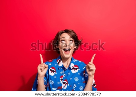 Portrait of charming astonished person look direct fingers up empty space festive ad isolated on red color background