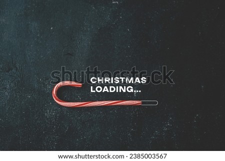 Christmas loading inscription on a black background and candy.