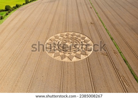 Aerial view of an intricate geometric crop circle formation in a wheat field in Wiltshire, England, UK