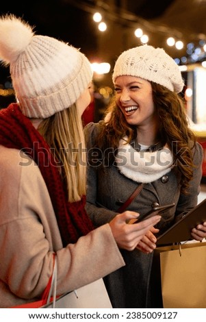 Christmas happy people digital tablet concept. Happy women friends enjoying shopping in the city