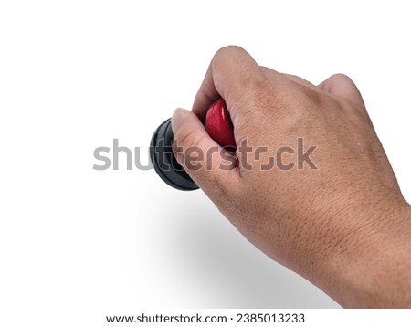 Hand holding red handled round rubber stamp, top view isolated on white with copy space Royalty-Free Stock Photo #2385013233