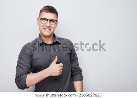 Portrait of young Caucasian man smiling joyfully showing thumbs up gesture isolated on white studio background. Approves good choice, right decision
 Royalty-Free Stock Photo #2385029623