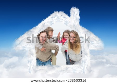 Happy couple piggybacking kids at beach against blue sky over clouds