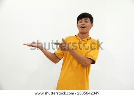 Adult Asian man showing excited expression while pointing to the right side