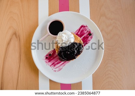 Raspberry pancake with whipped cream served in a cafe environment. 