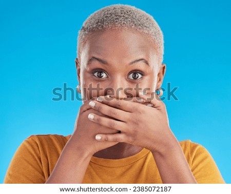 Gossip, secret or portrait black woman shocked by mistake or announcement in studio on blue background. Wow, fake news or surprised girl with excited, wtf or omg expression with hands to cover mouth Royalty-Free Stock Photo #2385072187