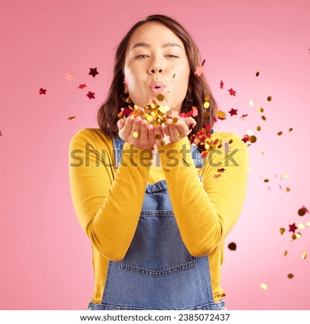 Portrait, celebration and Asian woman blow confetti to celebrate winner, happiness and excited at party event. Studio color, wow and creative Japanese person happy for birthday on pink background