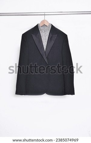 Blue suit jacket close up with gray sweater s on hanger 