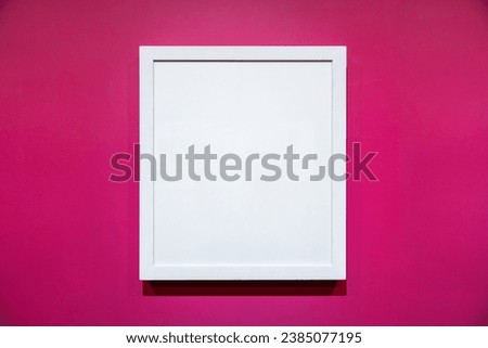 Blank white color picture frame template for place image inside on the colorful pink wall.