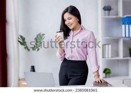 Portrait of Young beautiful positive Asian woman smiling standing in the office