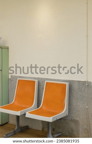 Two orange chairs next to an old green refrigerator.