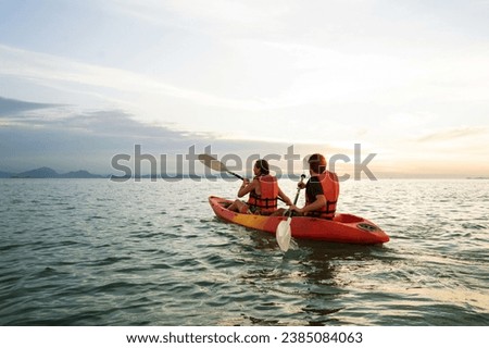 Couple kayaking at sunset in Thailand Royalty-Free Stock Photo #2385084063