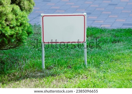 Pointer sign on the lawn green grass. Banner layout with place for the text dog walking is prohibited, do not walk on the lawn, it is dangerous, for sale. Information board layout. Mockup copy space