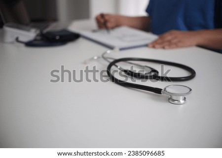 Doctor's working table. Focus on stethoscope. Female medicine doctor operating on background. Healthcare and medical concept Copy-space.